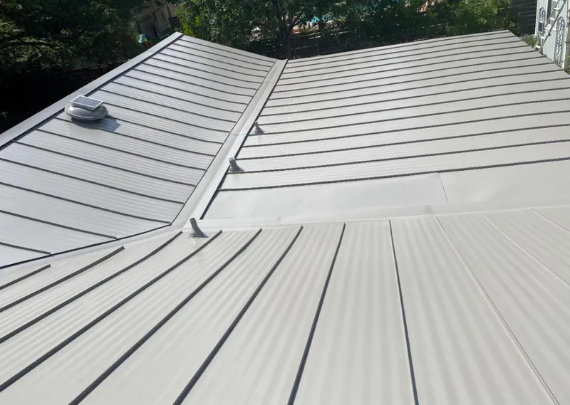 Solar attic fan installed on a metal roof for Roof Ventilation in Katy